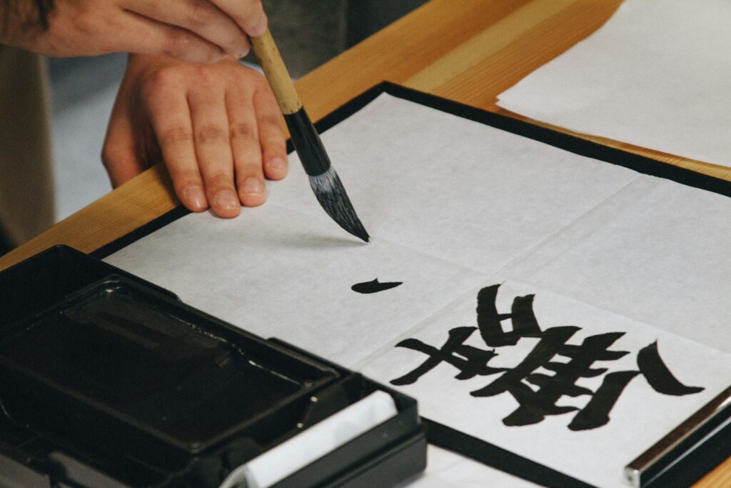 Persona escribiendo Kanji japonés con pincel